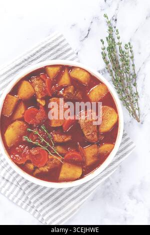 Fleischgulasch mit Kartoffeln und Karotten, Paprika, in einem Topf, Blick von oben, traditionelle ungarische Suppe, hausgemacht, keine Leute Stockfoto
