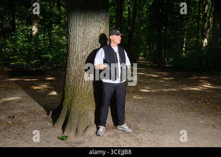 Hamburg, Deutschland. August 2025. Der Musiker und Rapper Disarstar (Gerrit Falius) steht vor einer Eiche im Volkspark Altona. Das neue Album des Hamburger Rappers „Hamburger Aufstand“ erscheint am 29. August. Quelle: Gregor Fischer/dpa/Alamy Live News Stockfoto