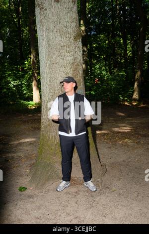 Hamburg, Deutschland. August 2025. Der Musiker und Rapper Disarstar (Gerrit Falius) steht vor einer Eiche im Volkspark Altona. Das neue Album des Hamburger Rappers „Hamburger Aufstand“ erscheint am 29. August. Quelle: Gregor Fischer/dpa/Alamy Live News Stockfoto