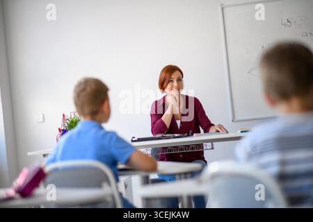 Lehrer, der mit Kindern in der Grundklasse spricht. Stockfoto