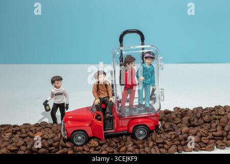 Miniaturmenschen wandern in einem Pickup auf der Oberfläche von Kaffeebohnen. Stockfoto