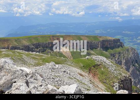 Panoramablick vom Gipfel des Schlers auf einen Bergkamm, der in steilen Klippen endet. Typische alpine Berglandschaft der Dolomiten. Stockfoto