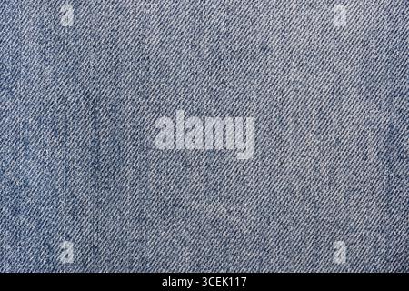 Nahaufnahme aus stonewashed Denim-Jeans-Stoff im Hintergrund. Traditionelles Kleidungsstoffkonzept. Stockfoto