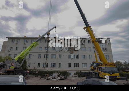 Charkiv, Ukraine. August 2025. Rettungskräfte räumen den Schutt eines Wohngebäudes, das durch einen russischen Angriff auf Charkiw, Ukraine, am Montag, den 18. August 2025 beschädigt wurde. Foto: Yevhen Titov/ABACAPRESS.COM Credit: Abaca Press/Alamy Live News Stockfoto