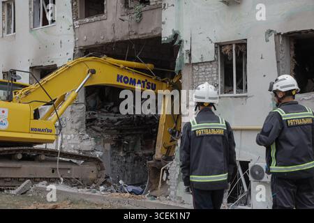 Charkiv, Ukraine. August 2025. Rettungskräfte räumen den Schutt eines Wohngebäudes, das durch einen russischen Angriff auf Charkiw, Ukraine, am Montag, den 18. August 2025 beschädigt wurde. Foto: Yevhen Titov/ABACAPRESS.COM Credit: Abaca Press/Alamy Live News Stockfoto