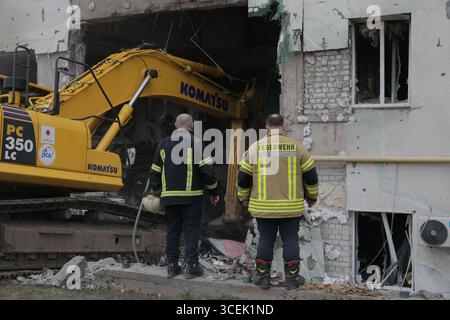 Charkiv, Ukraine. August 2025. Rettungskräfte räumen den Schutt eines Wohngebäudes, das durch einen russischen Angriff auf Charkiw, Ukraine, am Montag, den 18. August 2025 beschädigt wurde. Foto: Yevhen Titov/ABACAPRESS.COM Credit: Abaca Press/Alamy Live News Stockfoto