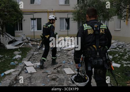 Charkiv, Ukraine. August 2025. Rettungskräfte räumen den Schutt eines Wohngebäudes, das durch einen russischen Angriff auf Charkiw, Ukraine, am Montag, den 18. August 2025 beschädigt wurde. Foto: Yevhen Titov/ABACAPRESS.COM Credit: Abaca Press/Alamy Live News Stockfoto