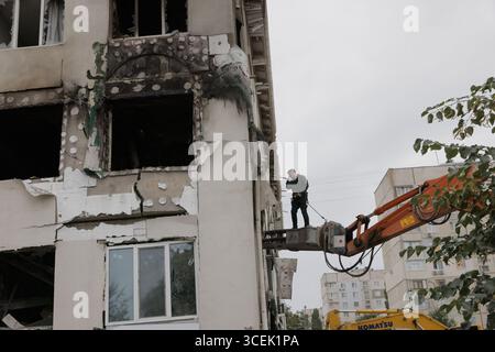 Charkiv, Ukraine. August 2025. Rettungskräfte räumen den Schutt eines Wohngebäudes, das durch einen russischen Angriff auf Charkiw, Ukraine, am Montag, den 18. August 2025 beschädigt wurde. Foto: Yevhen Titov/ABACAPRESS.COM Credit: Abaca Press/Alamy Live News Stockfoto