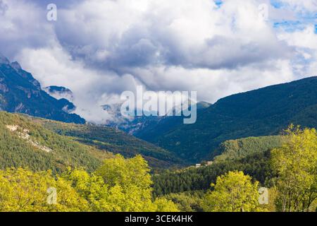 Panoramablick von Ordesa Aussichtspunkten in Richtung Monte Perdido, mit dramatischen Wolken über üppig grünen Tälern und bewaldeten Bergen in Aragon, Spanien. Stockfoto