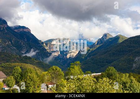 Panoramablick von Asín de Broto mit dramatischen Klippen, dichten Wäldern und nebeligen Gipfeln des Ordesa-Tals in den Pyrenäen, Aragon, Spanien. Stockfoto