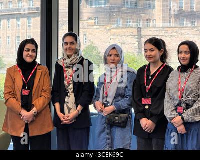 Muzhda Iqbal (links) mit afghanischen Medizinstudenten während eines Empfangs im Queen Elizabeth House der britischen Regierung in Edinburgh, das ein Jahr seit 19 Frauen aus Afghanistan nach Schottland gezogen sind, um Medizin zu studieren, nachdem die Taliban die Ausbildung von Frauen verboten hatten. Ausgabedatum: Montag, 18. August 2025. Stockfoto