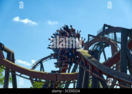 Passagiere hängen kopfüber auf der Nemesis Inferno Inverted Achterbahn im Thorpe Park, Surrey, England, Großbritannien. Stockfoto