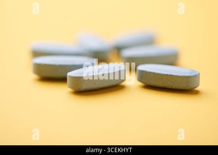 Multivitamintabletten auf hellem Papierhintergrund. Nahaufnahme. Kopierbereich Stockfoto