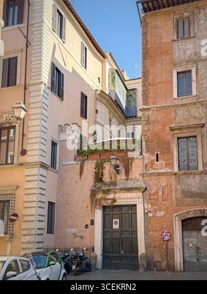 Historische Gebäude mit verschiedenen architektonischen Stilen und Farben säumen eine enge Straße in Rom, Italien Stockfoto