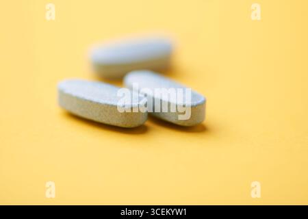 Multivitamintabletten auf hellem Papierhintergrund. Nahaufnahme. Kopierbereich Stockfoto