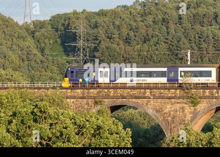 Ein Elektrotriebwagen der British Rail Class 333, der von Northern Trains über ein Viadukt auf der Wharfedale Railway Line in Baildon, Yorks, betrieben wird. Stockfoto