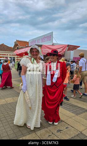 Zwei Damen in Kostümen von Belle Epoque posieren für ein Foto beim jährlichen Festival Soulac 1900. Juni 2025. Soulac-sur-Mer, Frankreich. Stockfoto