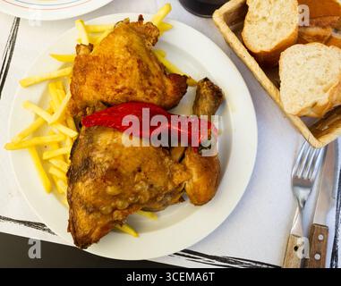 Gebacken mit rotem Paprikahuhn auf dem Teller mit pommes frites Stockfoto