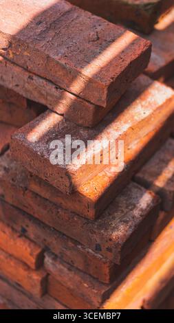 Die Textur roter Steine erzeugt einen klassischen und ästhetischen Look und dient als starkes und langlebiges Architekturelement in der Konstruktion. Stockfoto