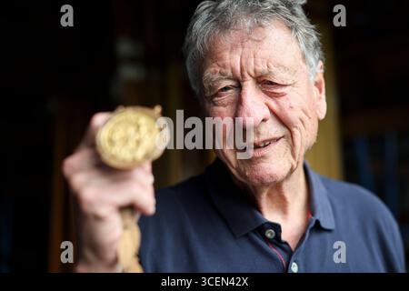 Ratzeburg, Deutschland. August 2025. Klaus Bittner, der einzige überlebende Ruderer der Goldmedaillengewinner von 1960, steht mit seiner Goldmedaille auf dem Set des Ratzeburg Ruderclub Bootshauses während der Dreharbeiten für den Film „Adam's Eight“. Die legendäre Deutsche Eiche und ihr Trainer Klaus Adam gewannen überraschend die Goldmedaille bei den Olympischen Spielen 1960 in Rom. Quelle: Christian Charisius/dpa/Alamy Live News Stockfoto