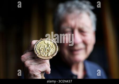 Ratzeburg, Deutschland. August 2025. Klaus Bittner, der einzige überlebende Ruderer der Goldmedaillengewinner von 1960, steht mit seiner Goldmedaille auf dem Set des Ratzeburg Ruderclub Bootshauses während der Dreharbeiten für den Film „Adam's Eight“. Die legendäre Deutsche Eiche und ihr Trainer Klaus Adam gewannen überraschend die Goldmedaille bei den Olympischen Spielen 1960 in Rom. Quelle: Christian Charisius/dpa/Alamy Live News Stockfoto