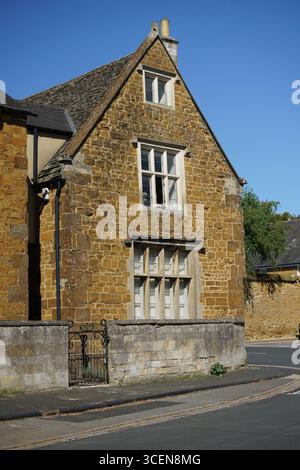 Historisches Steingebäude mit Fenstern an einem sonnigen Tag in einem ländlichen Dorf. Deddington, England Stockfoto