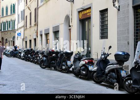 florenz firenze italien - eine Reihe von sauber geparkten Motorrollern am Straßenrand Stockfoto
