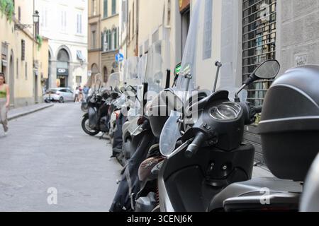 florenz firenze italien - eine Reihe von sauber geparkten Motorrollern am Straßenrand Stockfoto