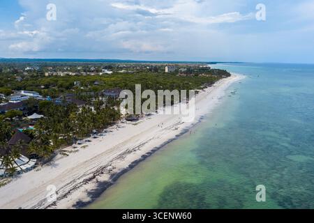 Aus der Vogelperspektive auf den weißen Sandstrand, der das türkisfarbene Meer unter einem Wolkenhimmel trifft, Diani Beach, Kwale County, Kenia. Stockfoto