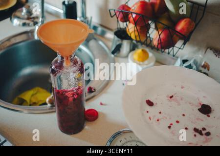 Spezialgetränk in einer Flasche, Himbeeren in Alkohol, gut für Körpermassage. Stockfoto