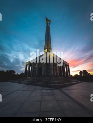 Das Kriegsdenkmal in Bratislava, Slowakei, das in der Abenddämmerung mit einem dramatischen Sonnenuntergang beleuchtet ist, erinnert an sowjetische Soldaten, die während des Zweiten Weltkriegs gefallen sind Slavín Stockfoto