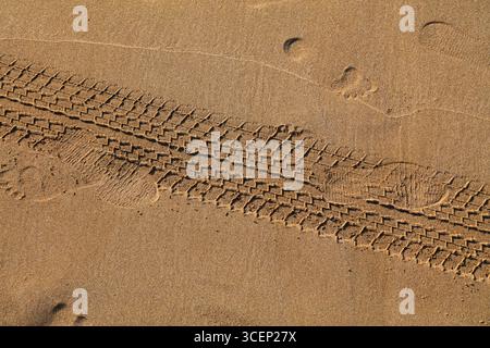 Autoreifenspuren am Strand in Marokko. Aufgedruckte Reifenspuren. Stockfoto