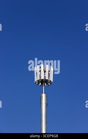 5 g Mobiltelefonmast mit unlackiertem Stahlmonopol und zwölf Antennen-Array, mit blauem Himmel und hellem Sonnenschein in whitefield Greater manchester uk Stockfoto