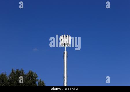 5 g Mobiltelefonmast mit unlackiertem Stahlmonopol und zwölf Antennen-Array, mit blauem Himmel und hellem Sonnenschein in whitefield Greater manchester uk Stockfoto