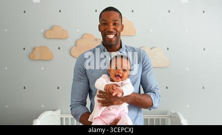 Porträt Von Vater Kuschelkind-Tochter Im Kinderzimmer Mit Wolken Dekoriert Stockfoto