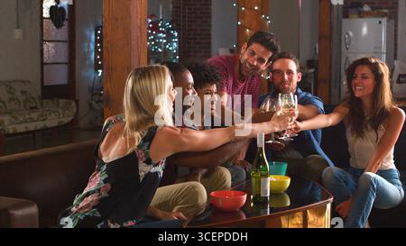 Gruppe Junger Freunde, Die Bei Einer Abendlichen Drink Party Im Loft Apartment Feiern Stockfoto