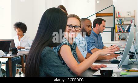 Zwei Businessfrauen, Die Informelle Meetings An Den Schreibtischen Im Modernen Open Plan Office Durchführen Stockfoto