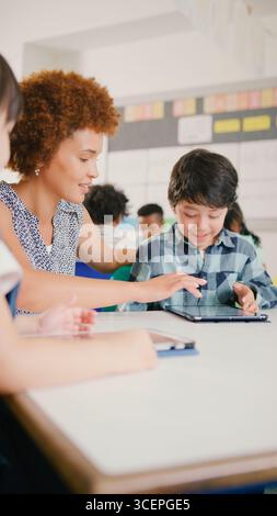 Lehrerin mit Grundschulschülern mit digitalem Tablet in der MINT-Klasse Stockfoto