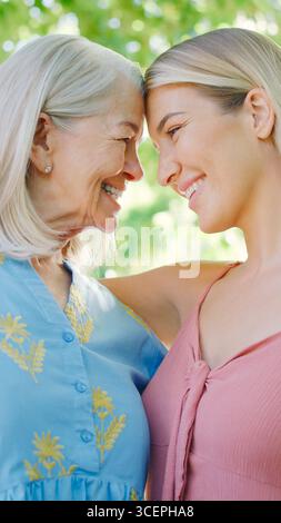 Mehrgenerationenfamilie Mit Älterer Mutter Und Erwachsener Tochter, Die Im Garten Lachen Stockfoto