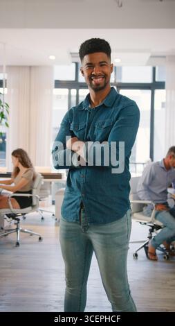 Porträt Eines Jungen Lächelnden Geschäftsmannes, Der Im Modernen Büro Steht Stockfoto