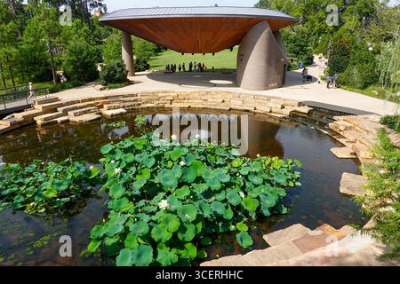 An einem schönen Sommertag versammeln sich Menschen im Great Lawn and Pavilion Area von Downtown Cary, North Carolina Park. Stockfoto