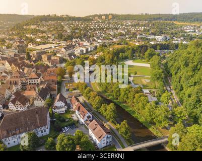 Der Fluss verläuft durch eine Stadt in herbstlicher Landschaft, umgeben von üppigem Grün und Stadtgebäuden, Nagold, Calw Bezirk, Schwarzwald, Deutschland Stockfoto