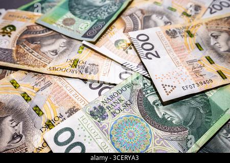 Polnische Banknoten von hundertzweihundert Zloty, zufällig verteilt. Hintergrund polnischer Zlotys. Hochwertige Fotos Stockfoto