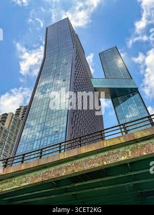 New York, NY - 19. Juni 2025:: Leaning American Copper Buildings with Skybridge Stockfoto