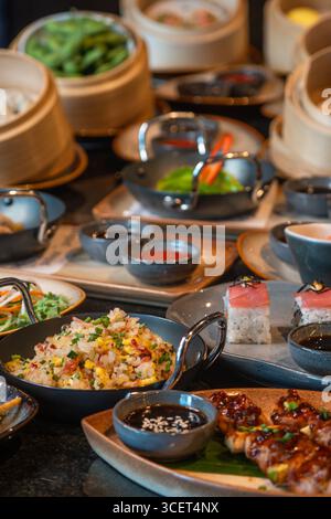 Auswahl chinesischer Speisen. Chinesische Nudeln, gebratener Reis, Knödel, Dim Sum, Frühlingsrollen. Berühmte chinesische Gerichte auf schwarzem Hintergrund Stockfoto