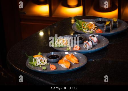 Frische Sushi Rolls mit Lachs und Thunfisch, japanische Küche auf einem Gourmet-Teller mit Meeresfrüchten Stockfoto