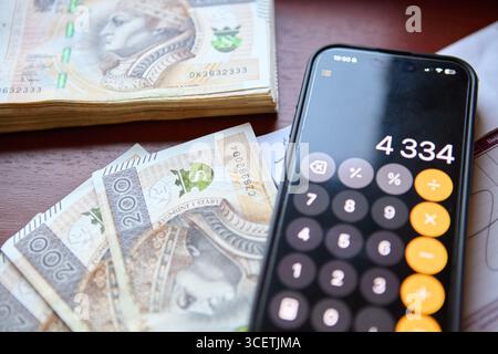 Verbreitung polnischer Zloty-Banknoten auf dem Schreibtisch mit Taschenrechner Stockfoto