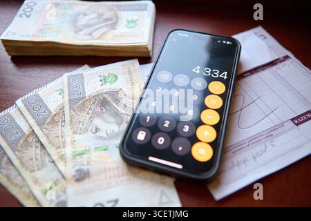 Verbreitung polnischer Zloty-Banknoten auf dem Schreibtisch mit Taschenrechner Stockfoto