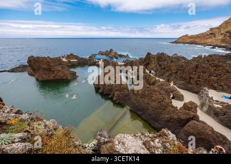 Porto Moniz, Madeira, Portugal – 7. Juli 2025; natürliche Lavabecken mit Meereswasser. Touristen schwimmen in Lavapools. Hochwertige Fotos Stockfoto