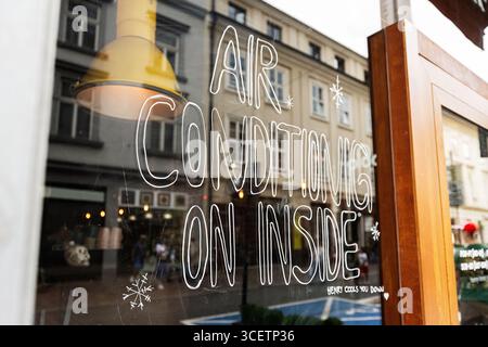 Eine Glasfront in Krakau mit einem Schild über die verfügbaren Klimaanlagen. Stockfoto